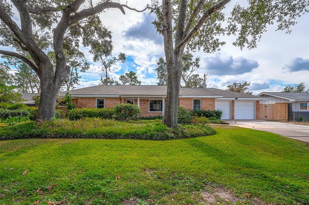 a front view of a house with a yard and trees