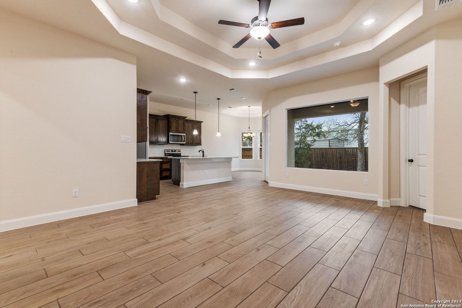 a view of a kitchen with wooden floor and a ceiling fan