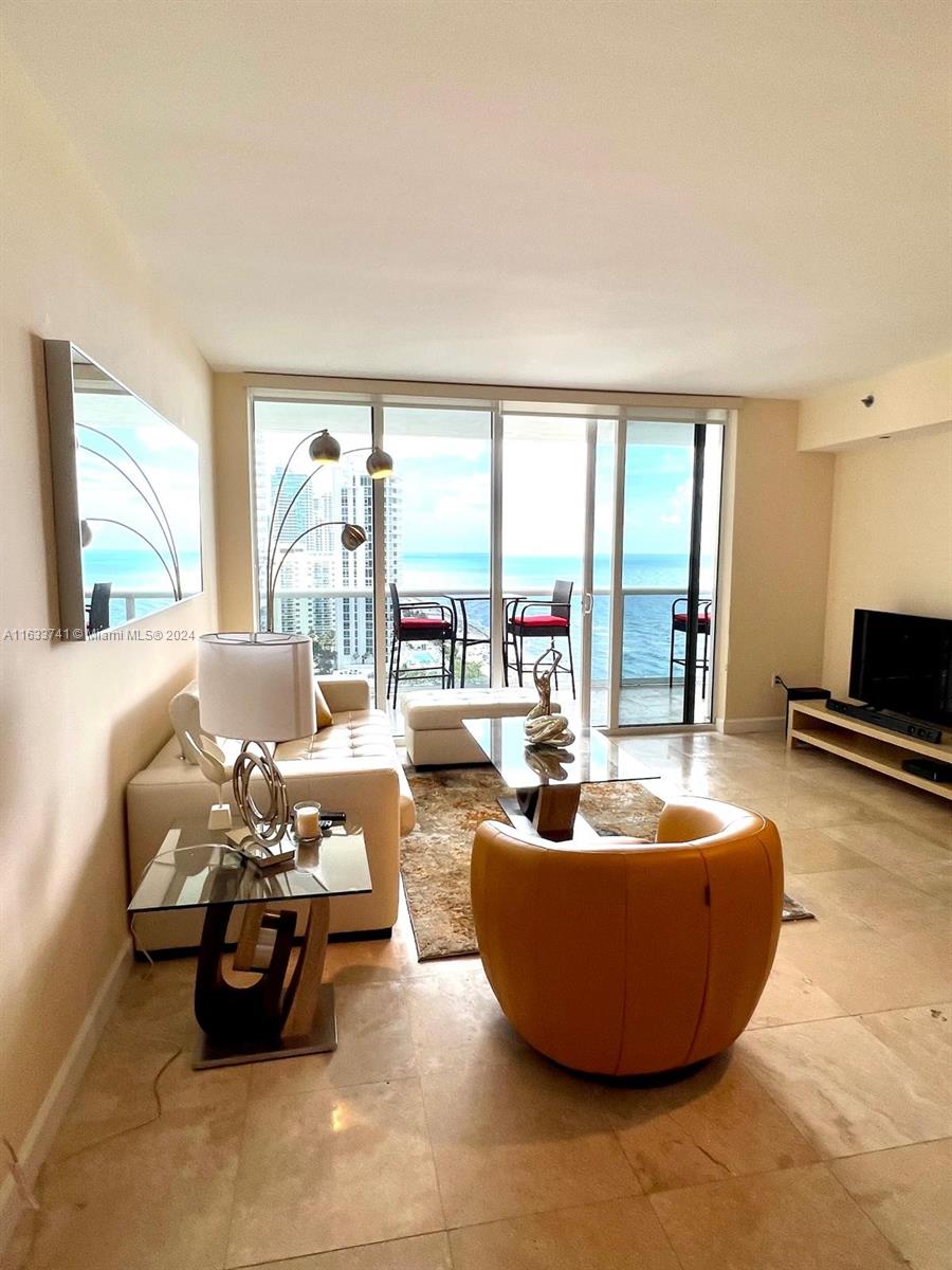 a living room with furniture and a floor to ceiling window