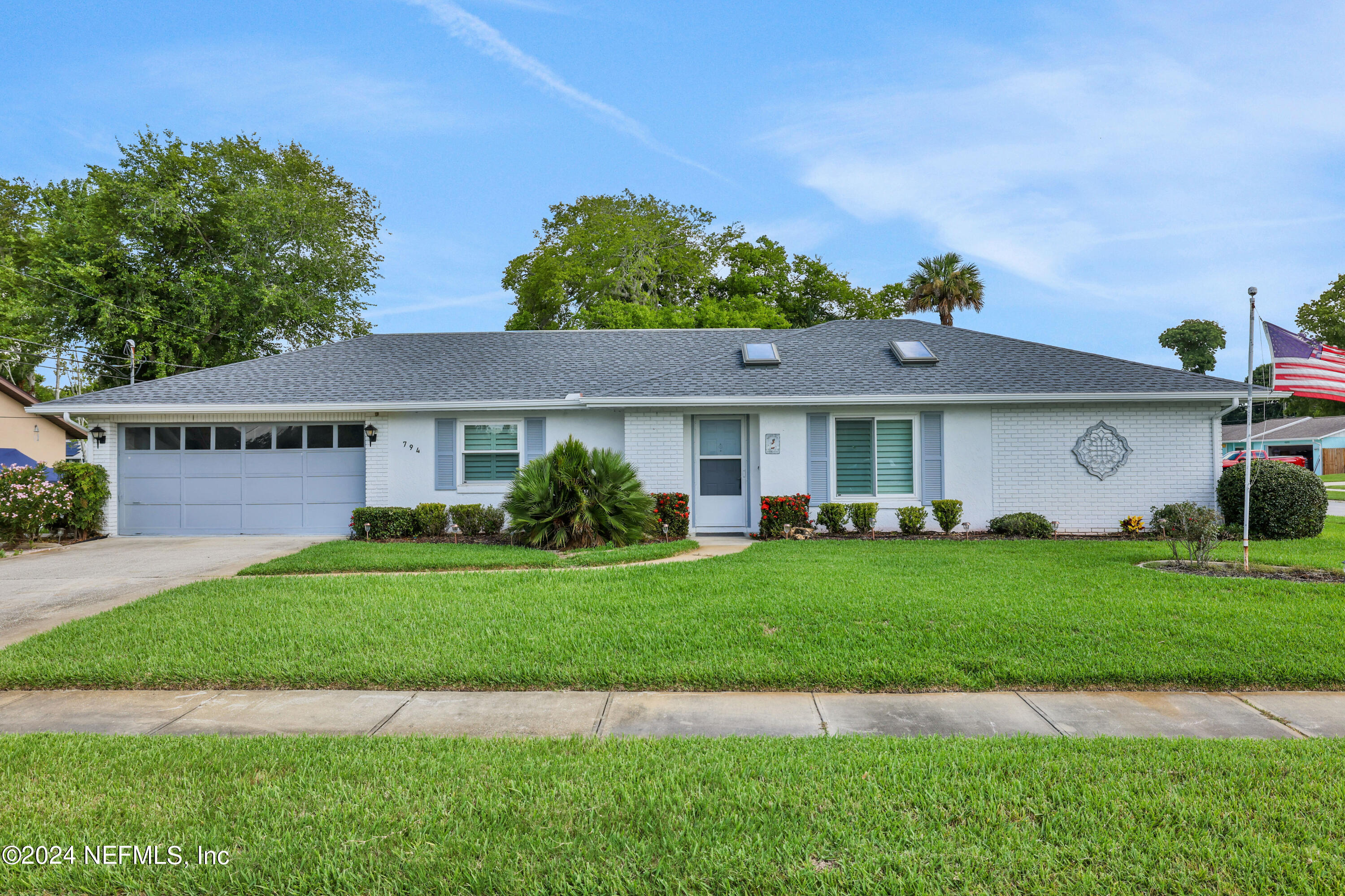 a front view of a house with a garden and deck