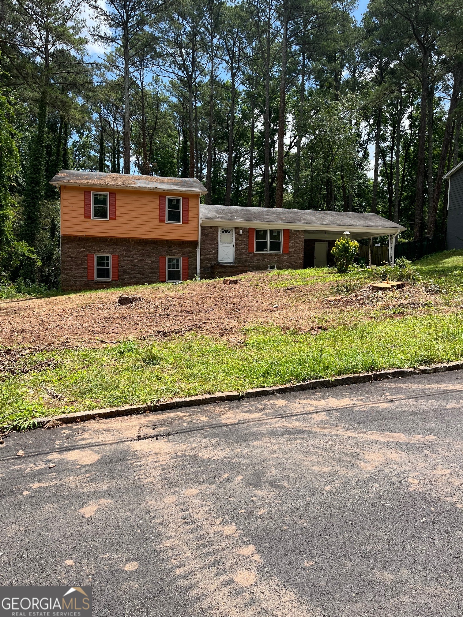 a front view of a house with a garden and trees