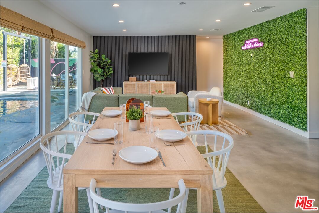 a dining room with furniture a large window and kitchen view