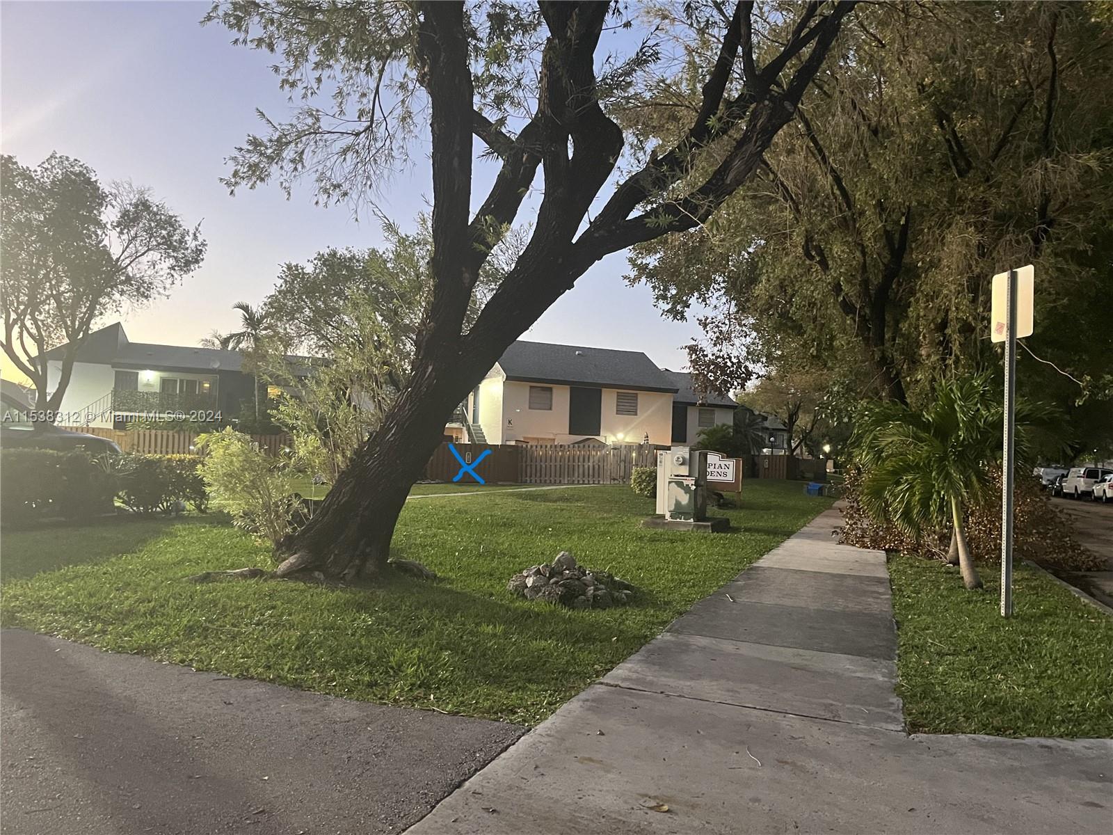 a front view of a house with a yard and trees