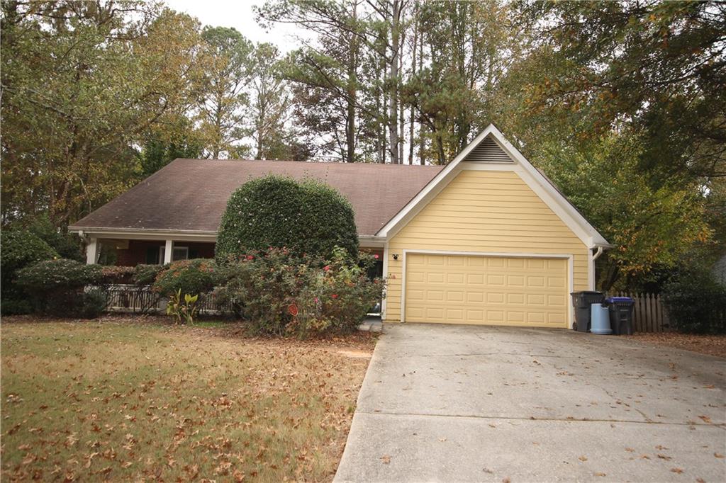 a view of a house with a yard and large tree