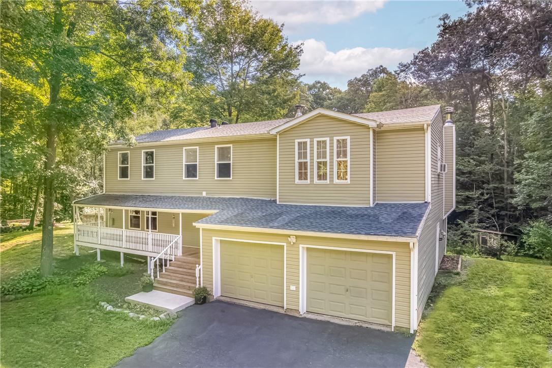 View of front of home featuring a porch, a garage, and a front yard