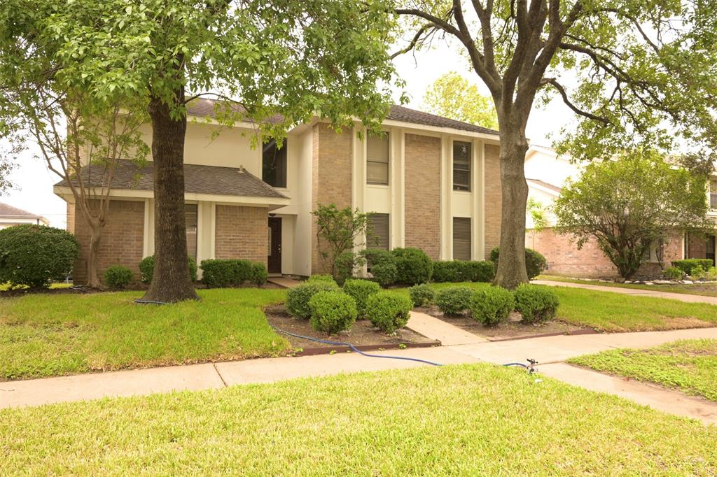 a front view of a house with a yard and trees