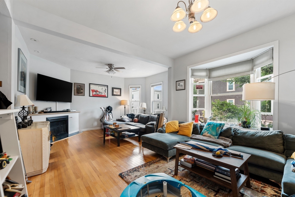 a living room with furniture a flat screen tv and kitchen view