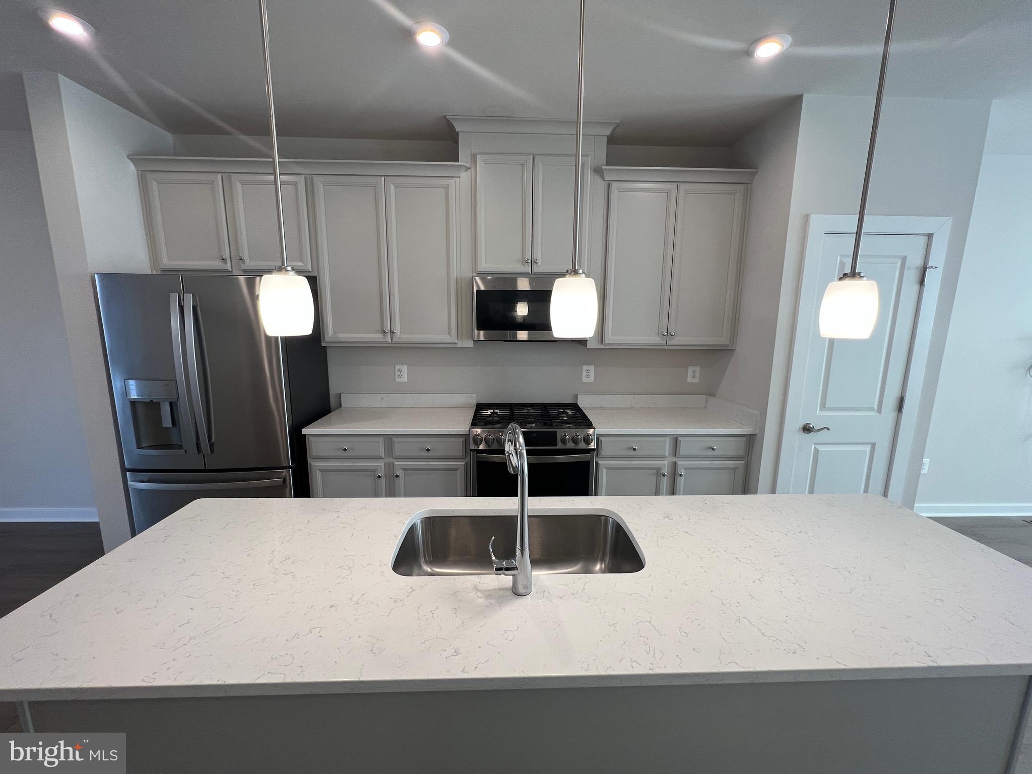 a kitchen with a sink a refrigerator and cabinets