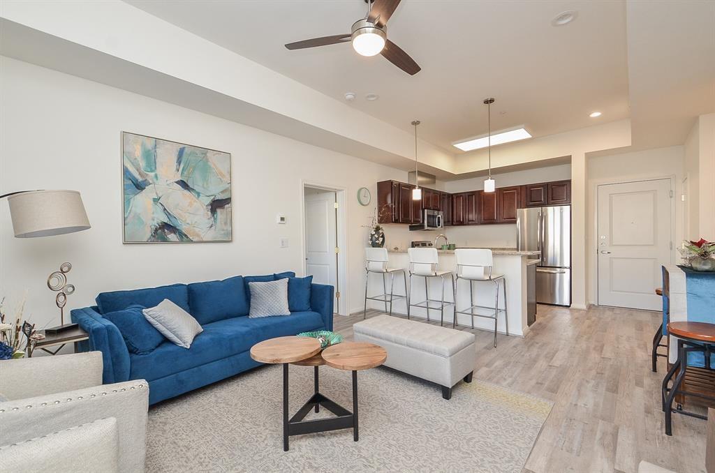 a living room with furniture and a dining table with kitchen view