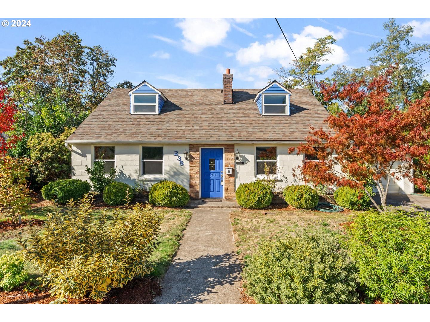 a view of a brick house with a yard and potted plants