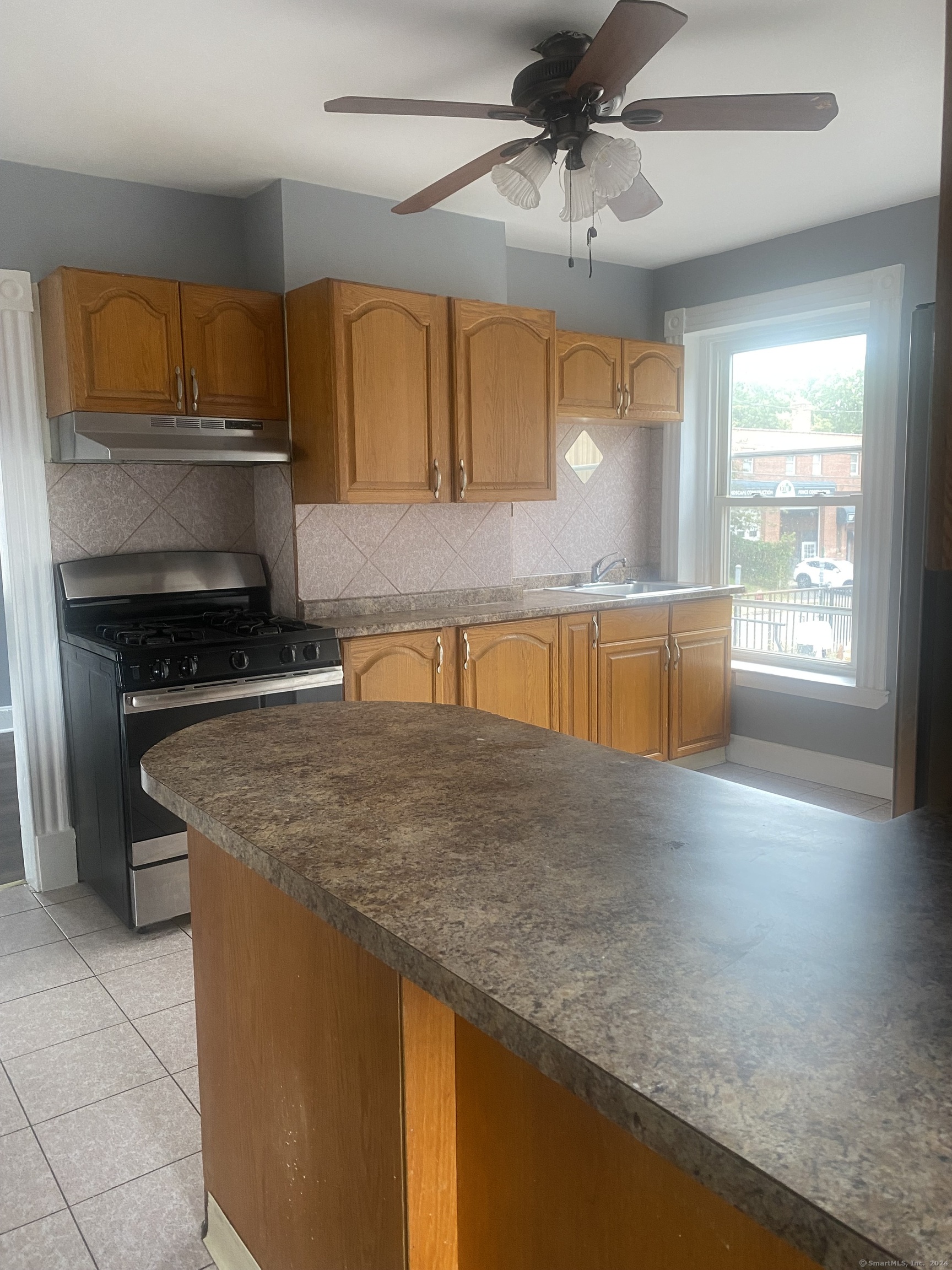 a kitchen with stainless steel appliances granite countertop a sink a stove and a wooden cabinets