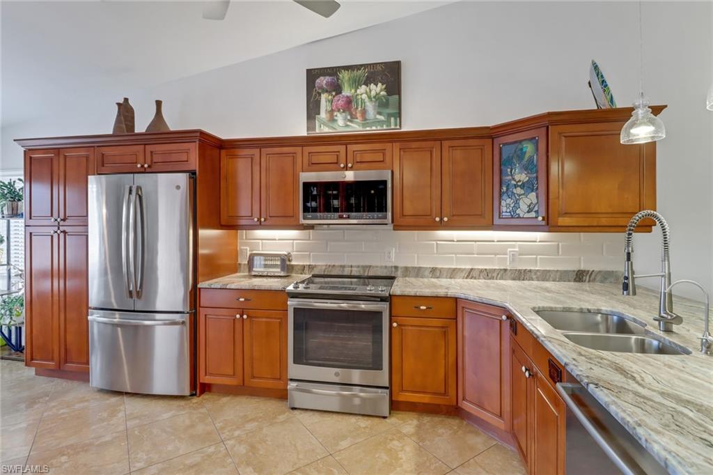 a kitchen with stainless steel appliances granite countertop a refrigerator stove and sink