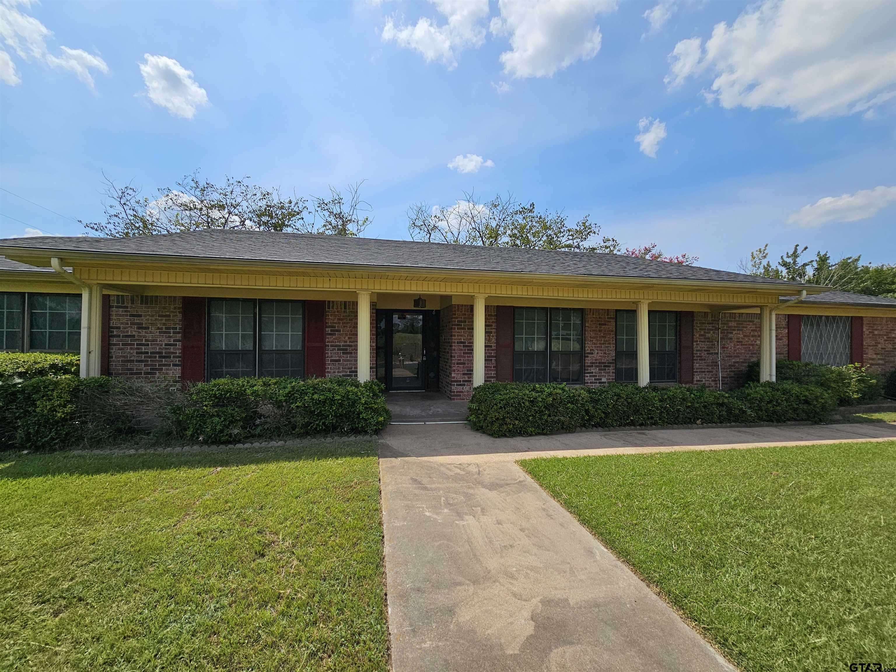 a view of a brick house with a yard