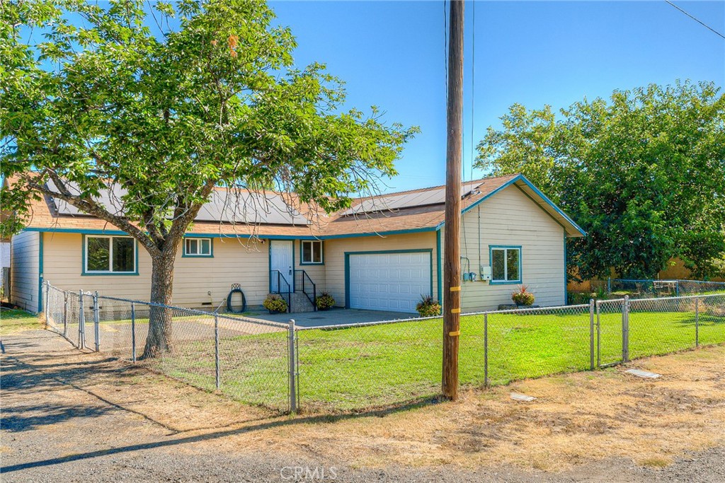 a view of a house with a yard and a large tree