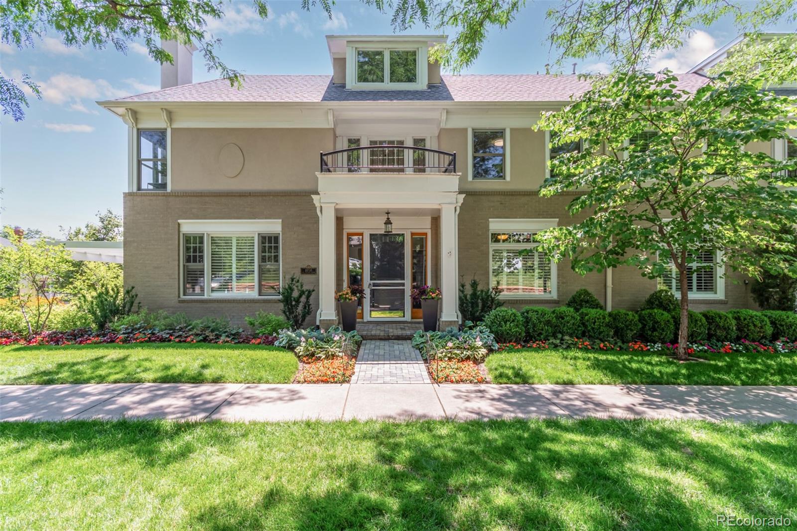 a front view of a house with a yard and plants