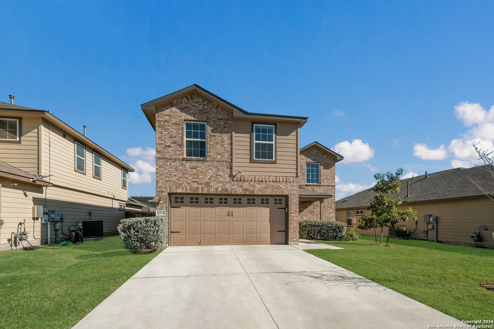 a front view of a house with a yard and garage