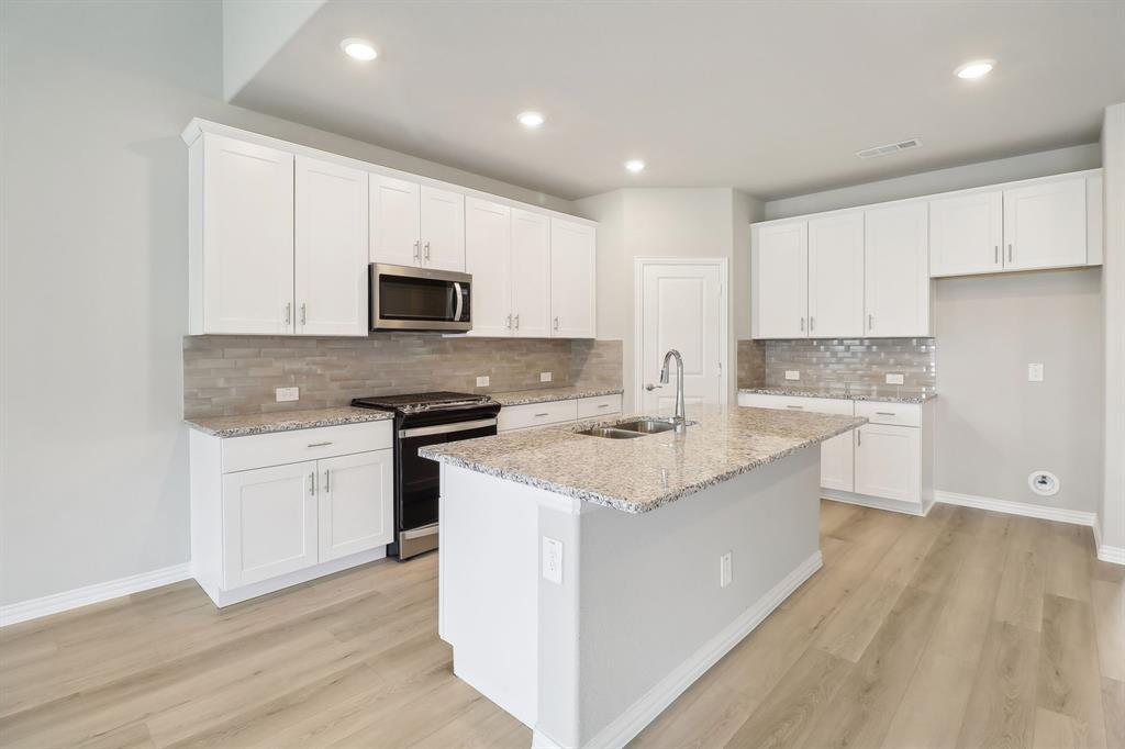 a kitchen with granite countertop white cabinets and white appliances