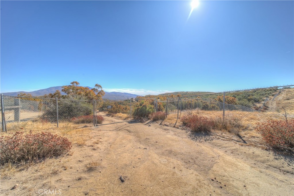 a view of a dry yard with mountains in the background