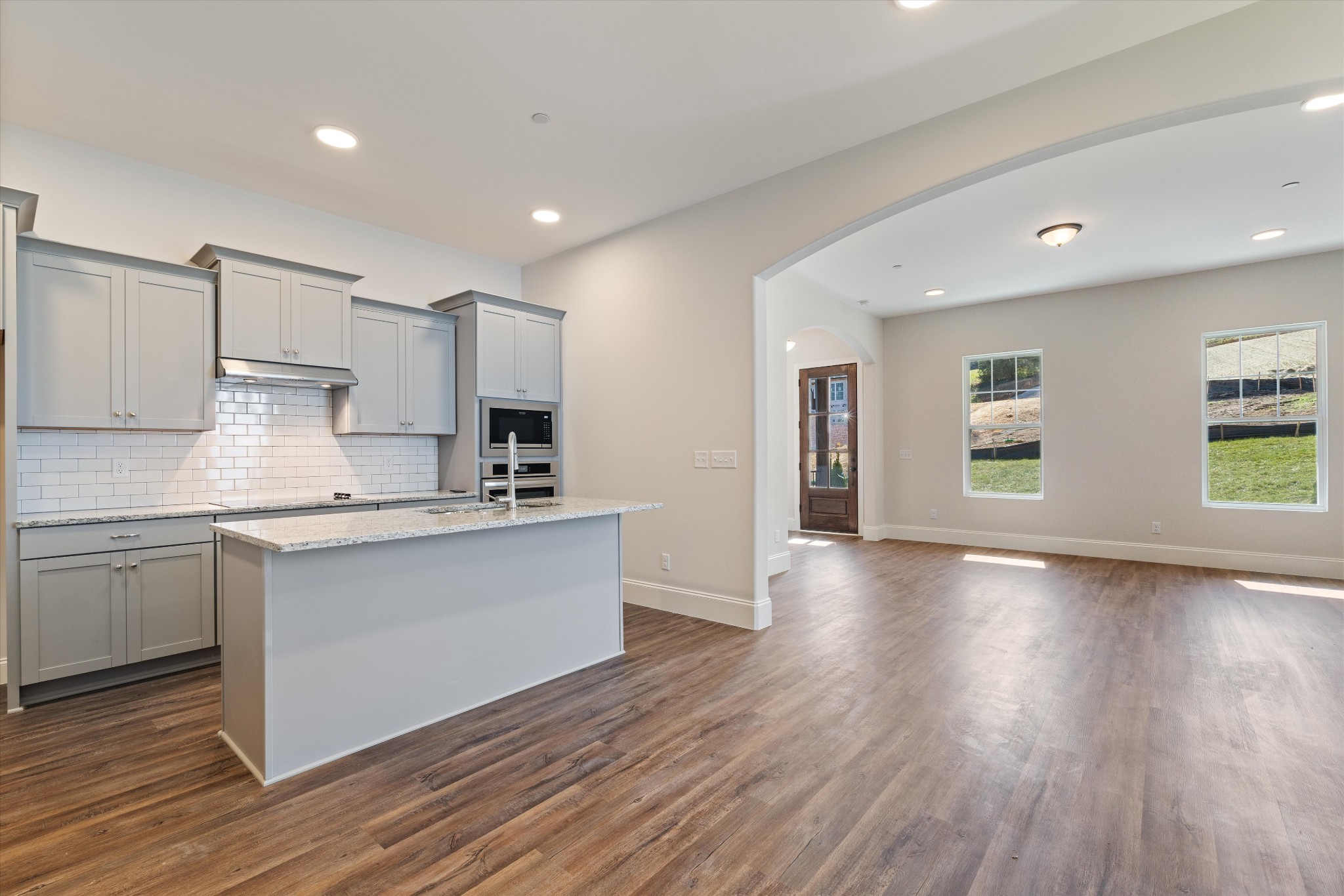 a large kitchen with stainless steel appliances granite countertop a large counter top and wooden floors