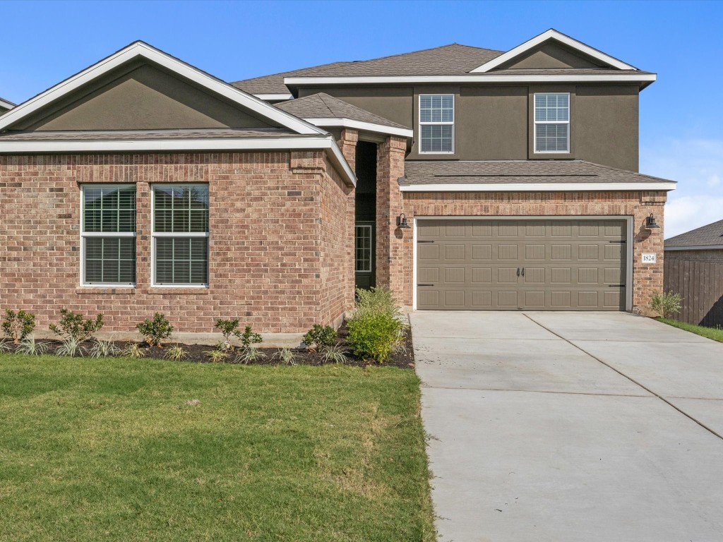 a front view of a house with a yard and garage