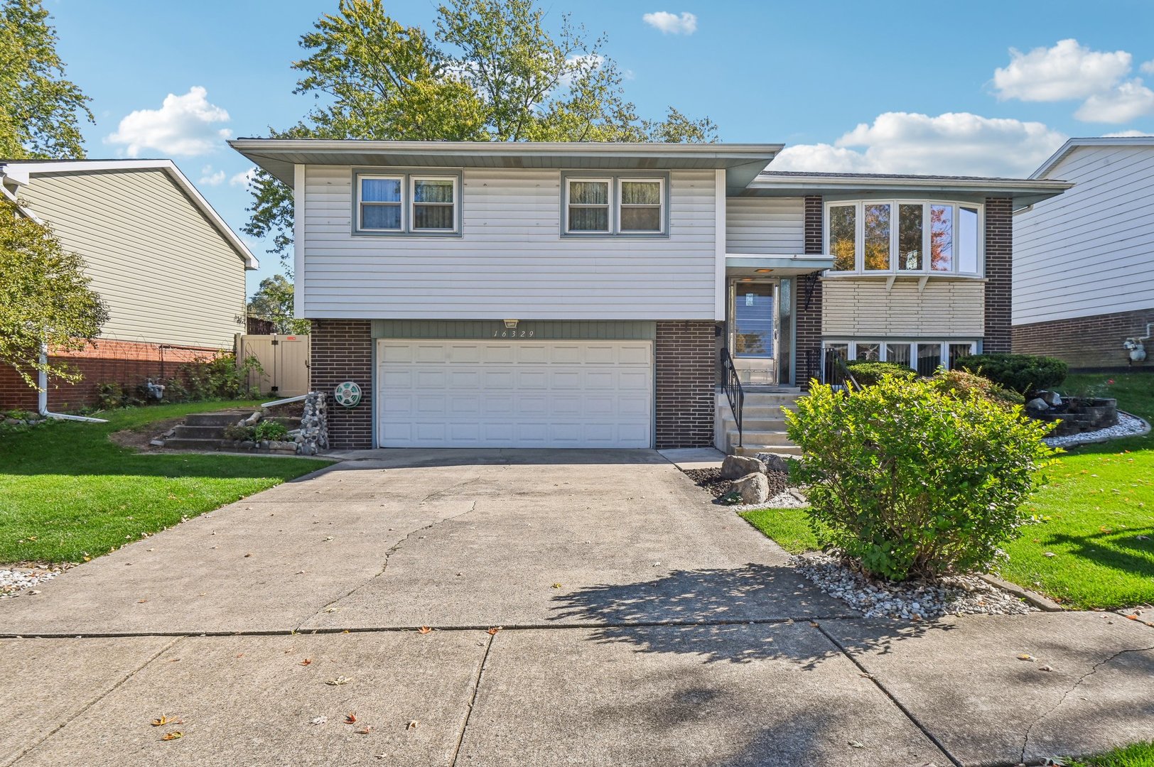 a front view of a house with a yard and a garage