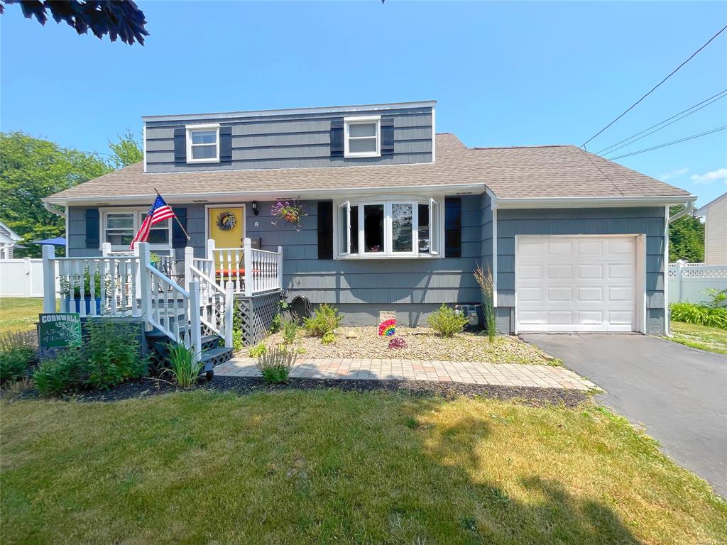 View of front of home featuring a front lawn, a porch, and a garage