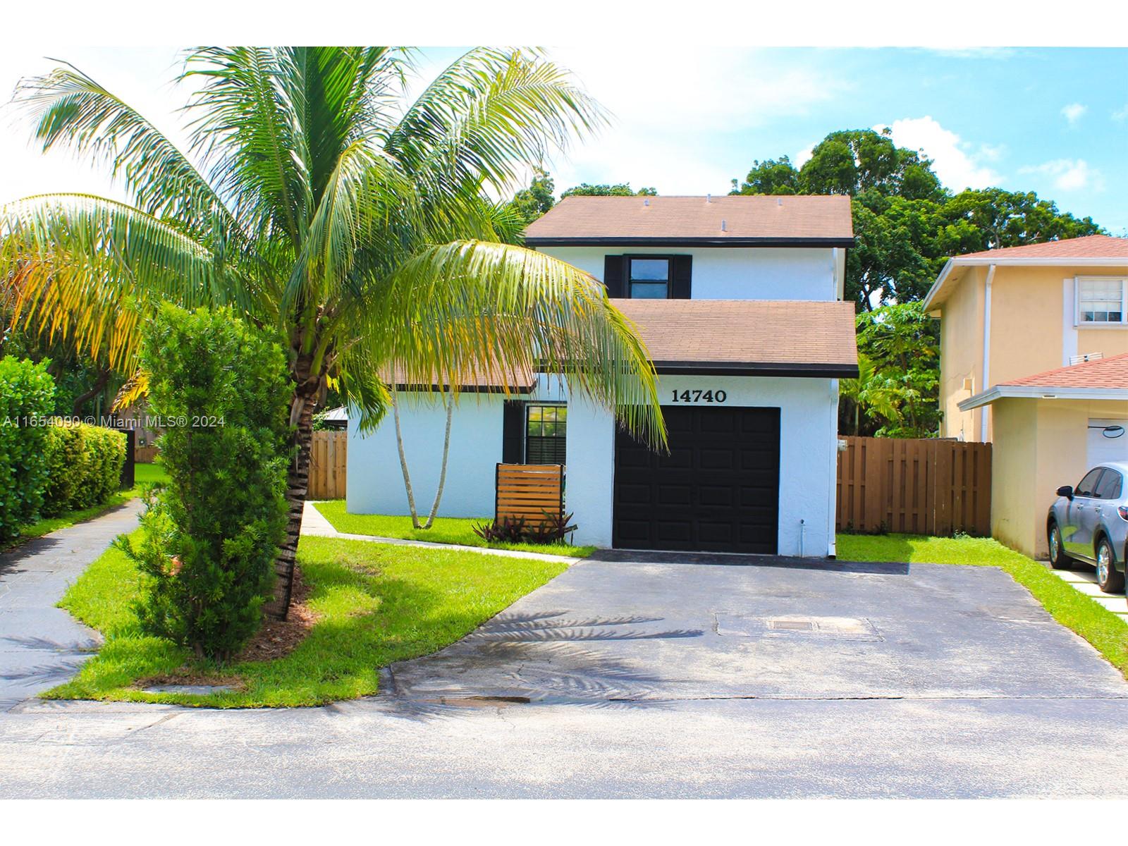 a front view of house with yard and trees