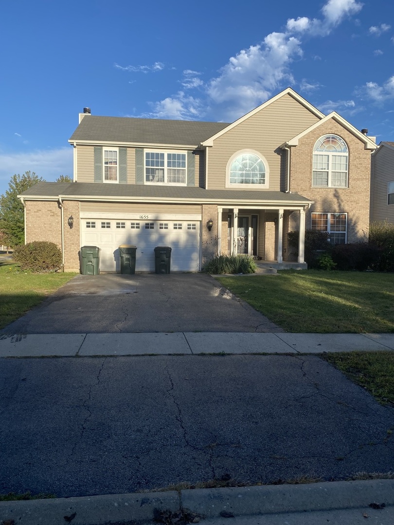 a front view of a house with a garden