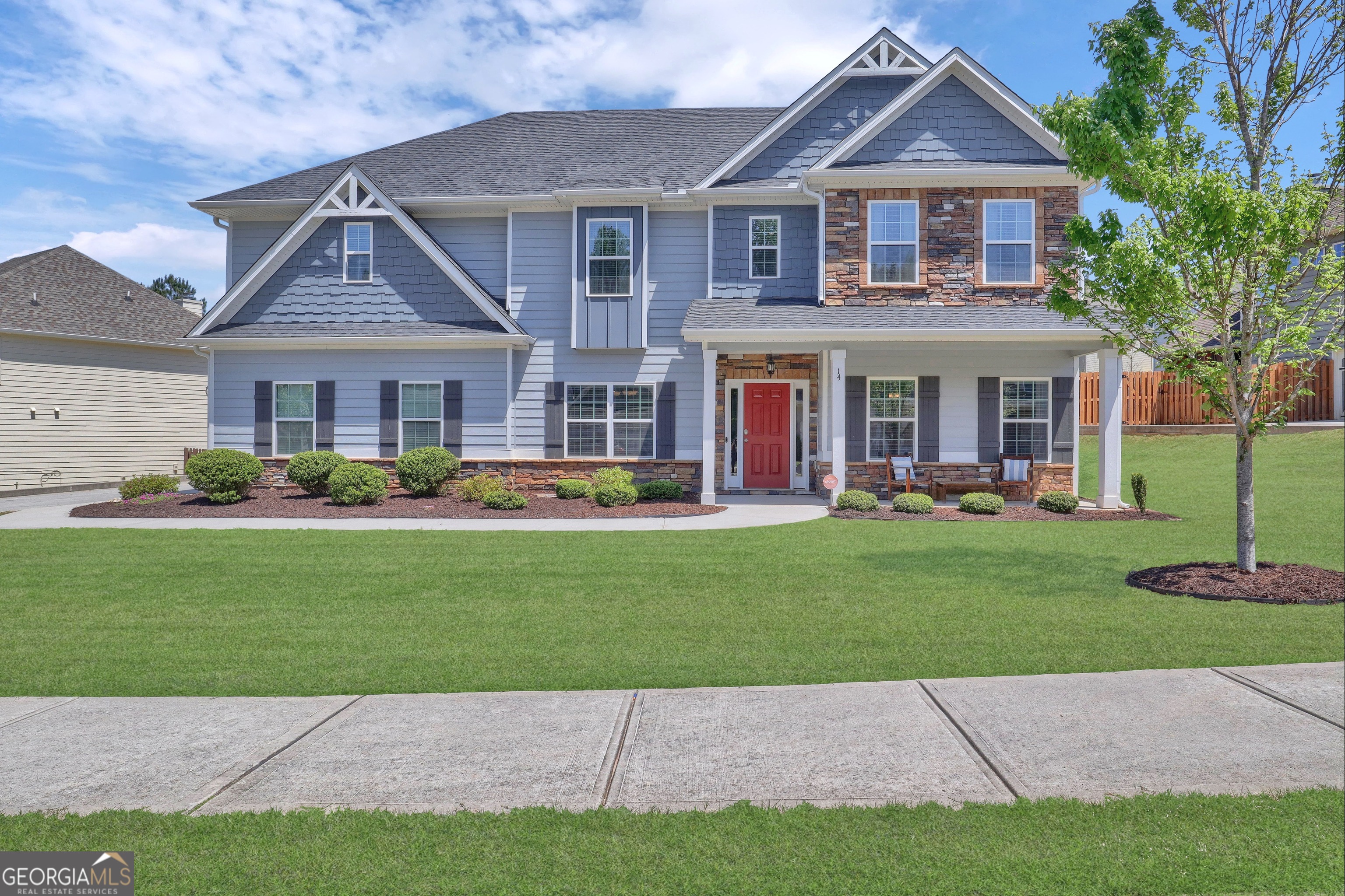 a front view of a house with a garden and yard