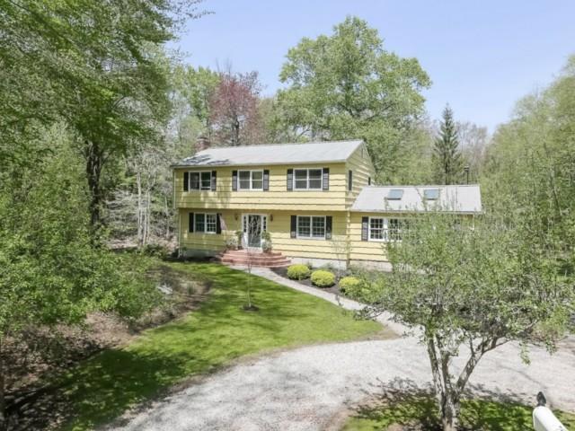 a view of a house with garden and trees