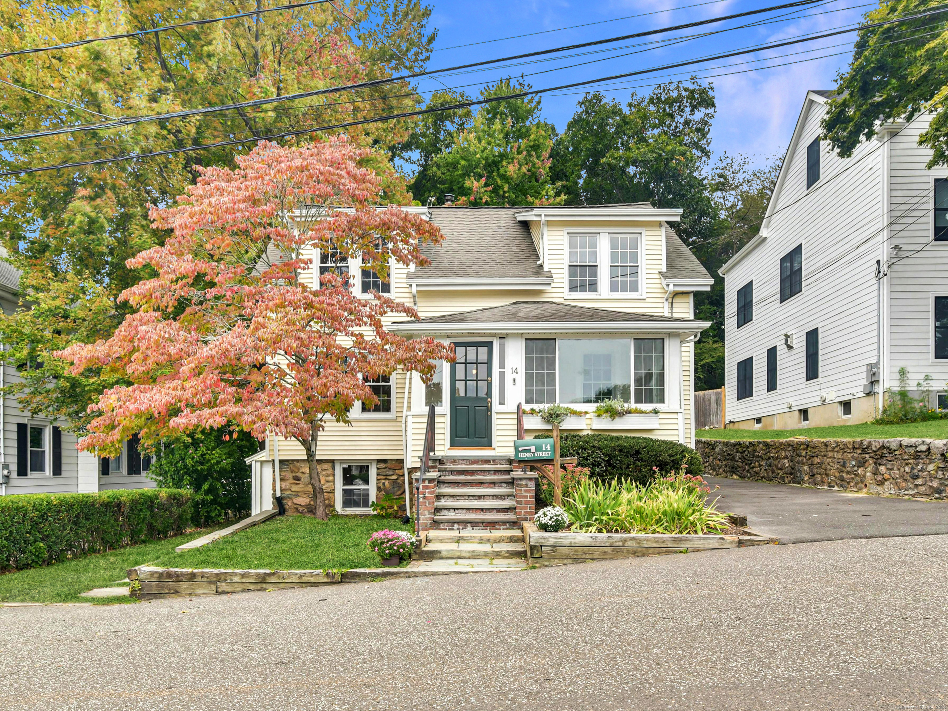 a front view of a house with a garden and plants