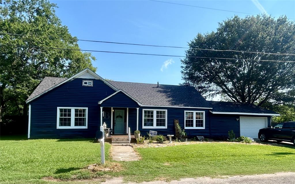 a front view of a house with a yard and trees