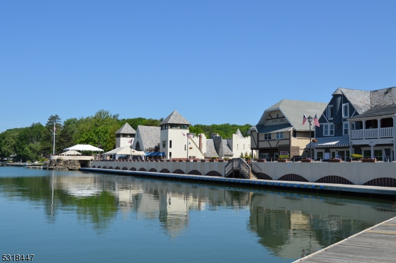 a view of house next to a lake with boats and trees