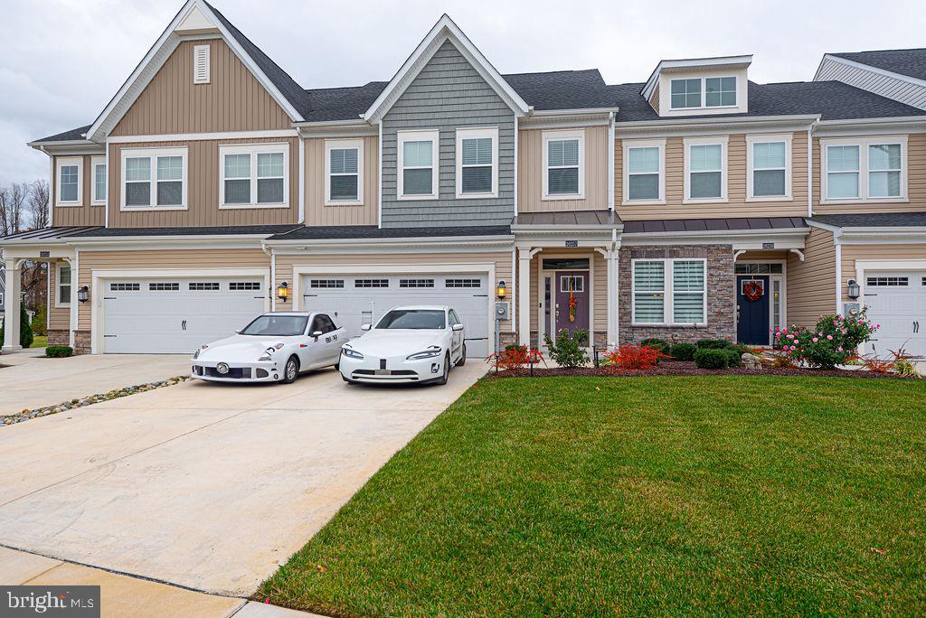 a front view of a house with a garden and parking space