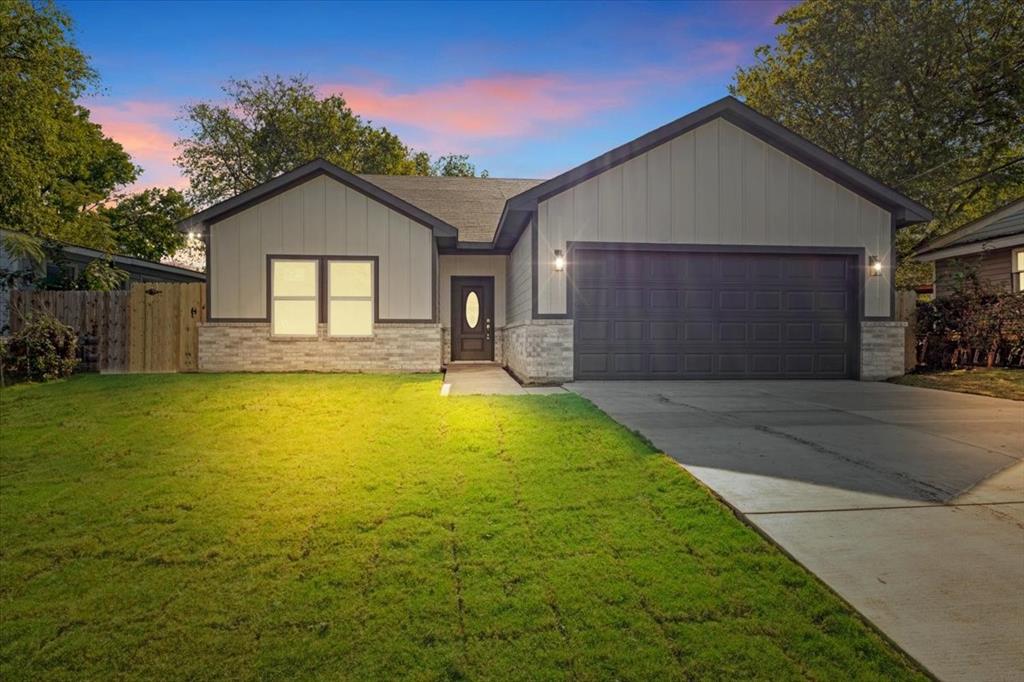 a front view of a house with yard and garage