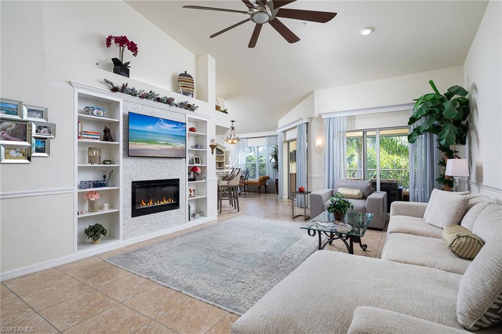 a living room with furniture fireplace and a large window