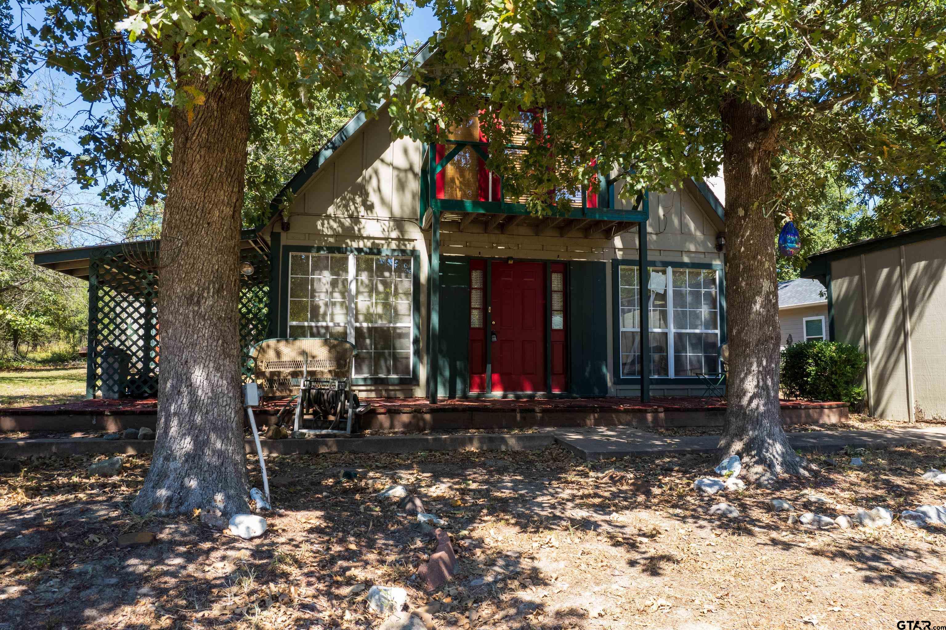 a view of a house that has a tree in front of it