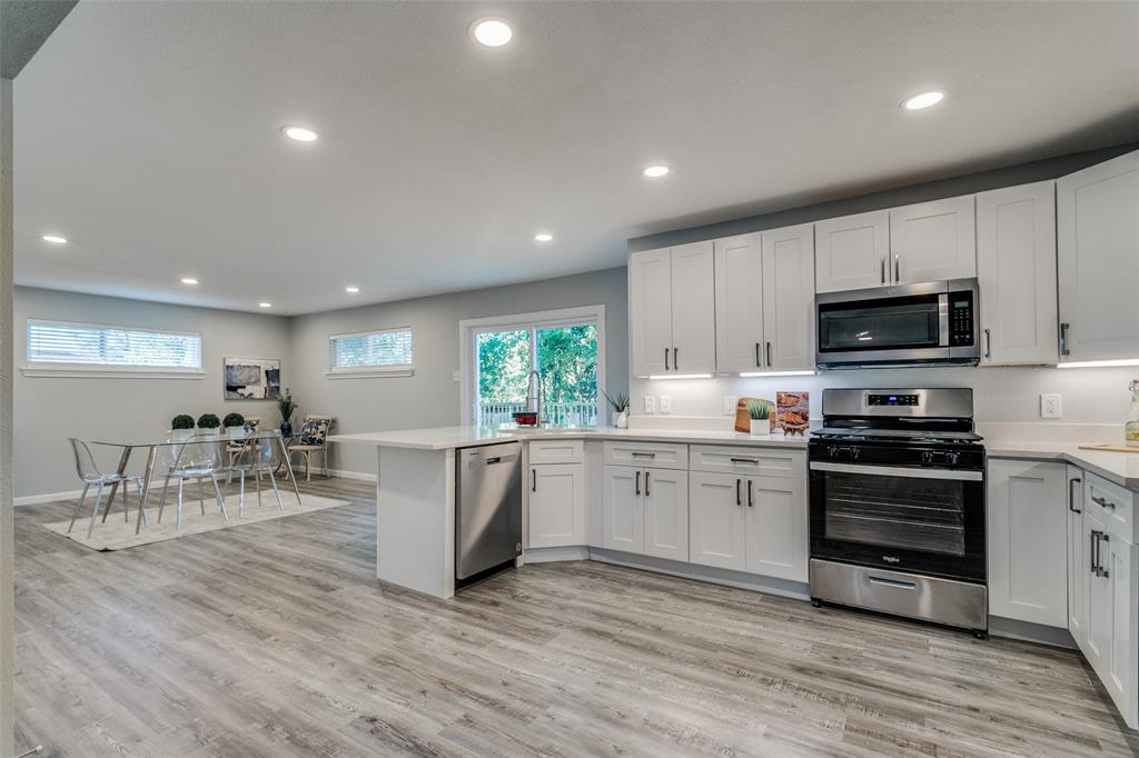 a kitchen with microwave a stove and cabinets