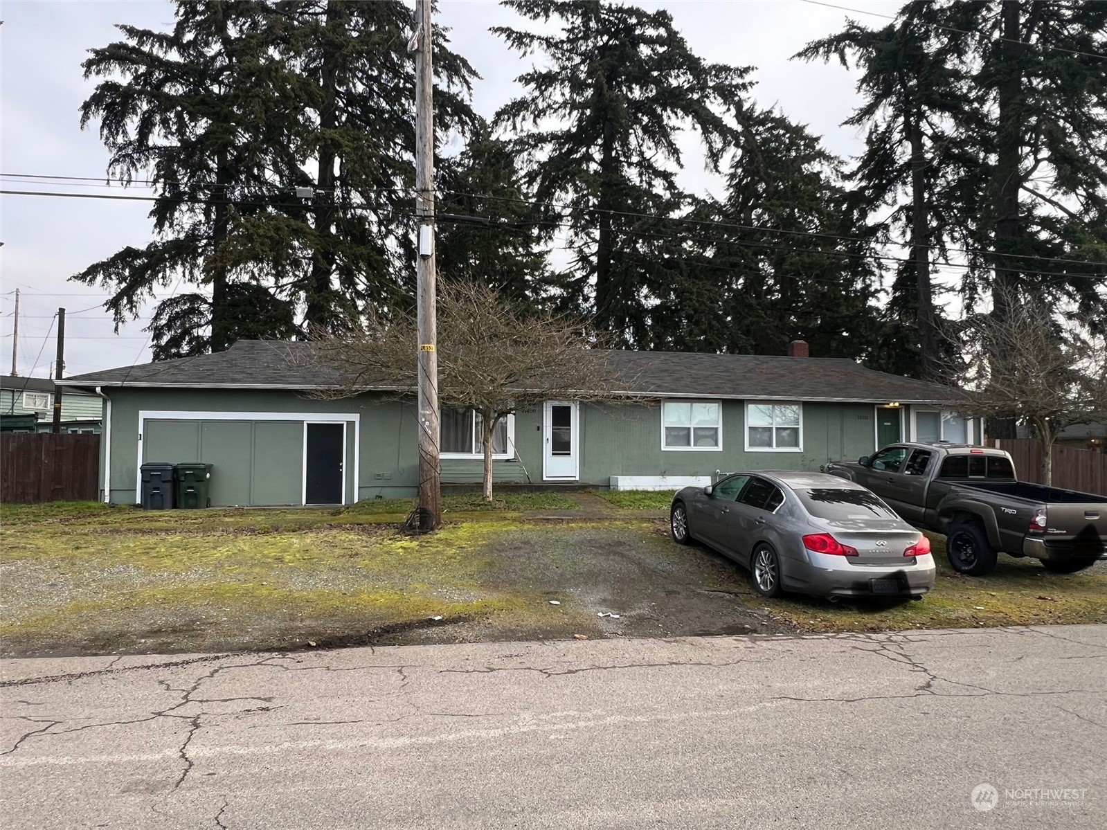 a front view of a house with cars parked