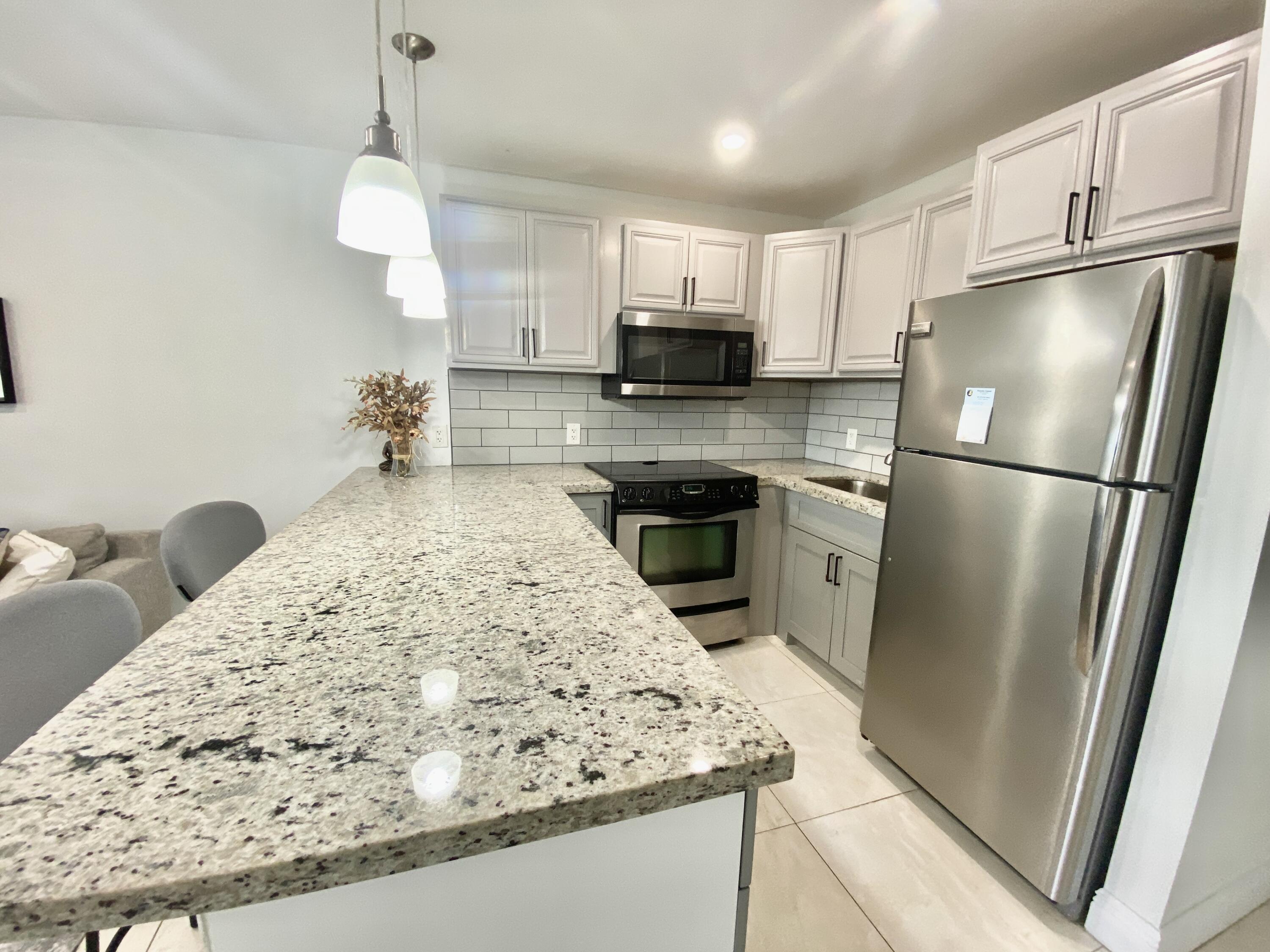 a kitchen with a sink a refrigerator a stove a microwave and cabinets