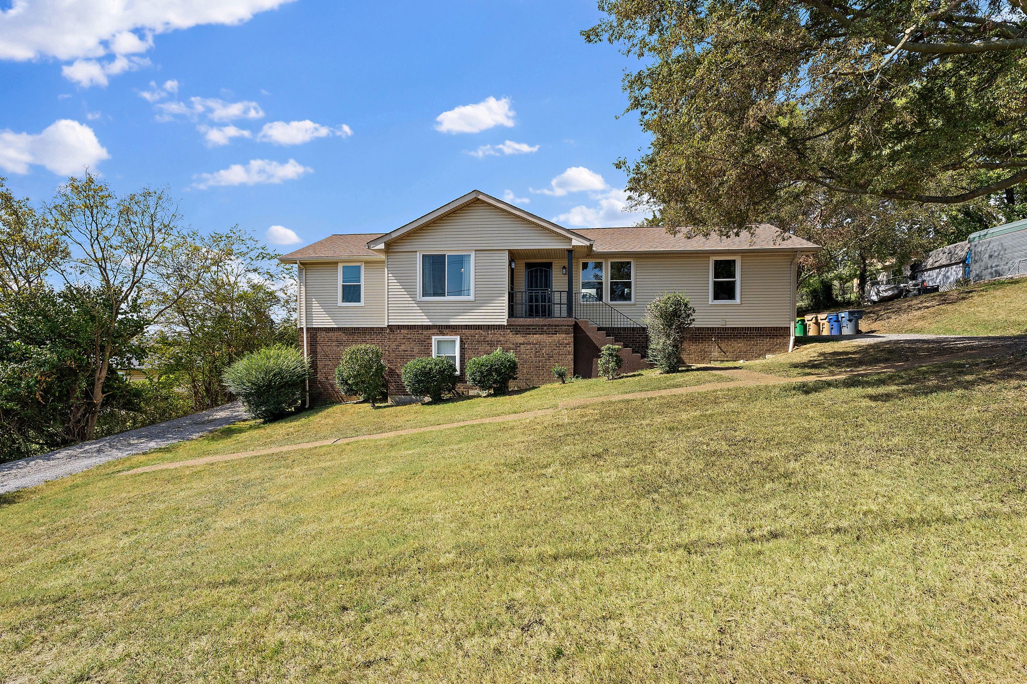 a front view of a house with a yard and trees