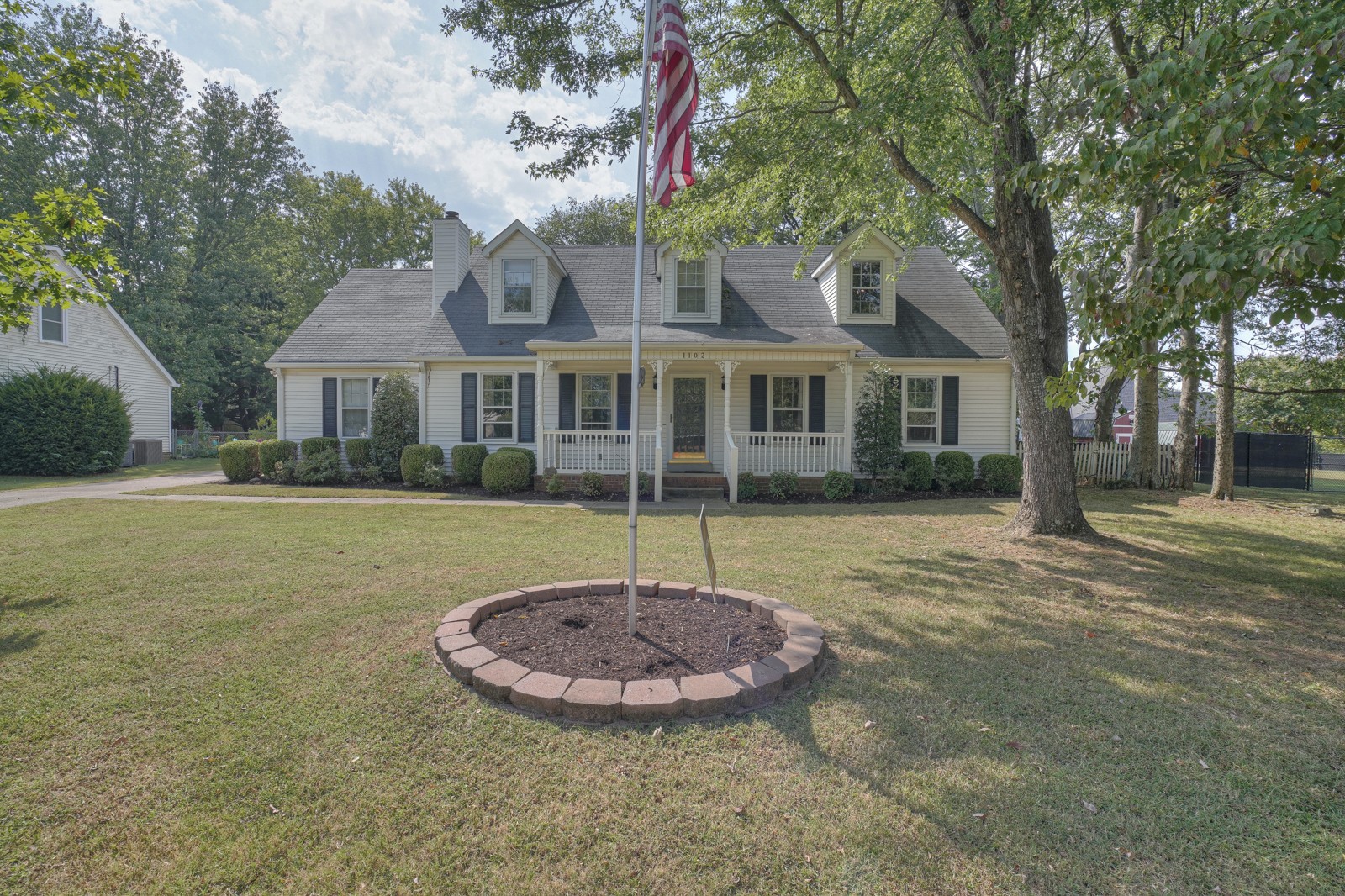 a view of a white house with a swimming pool and porch