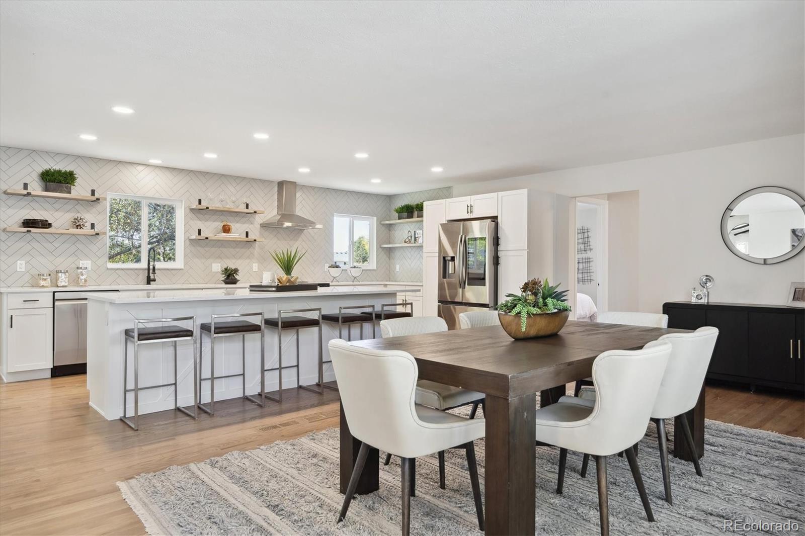 a kitchen with granite countertop a table chairs stove a sink and dishwasher