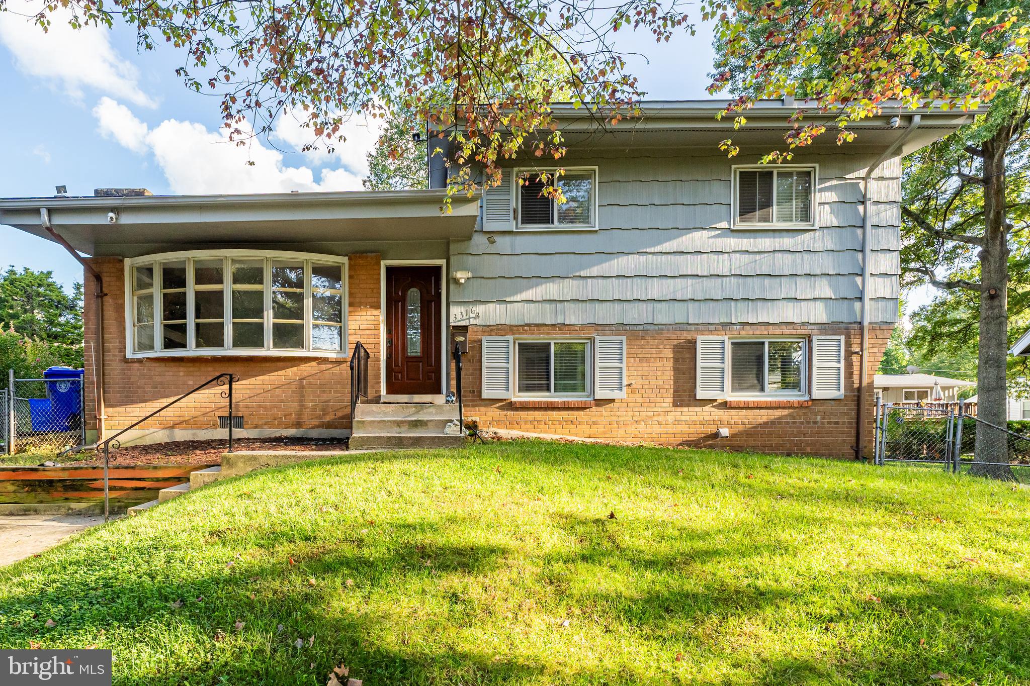 a view of a house with a yard patio and a tree