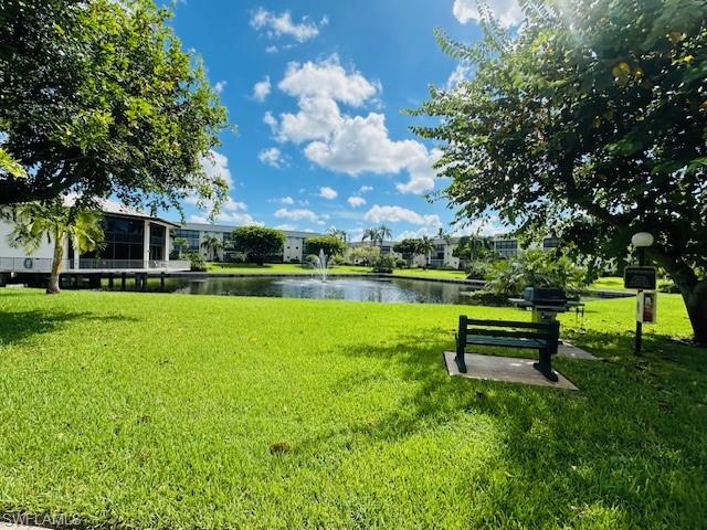 View of community featuring a yard and a water view