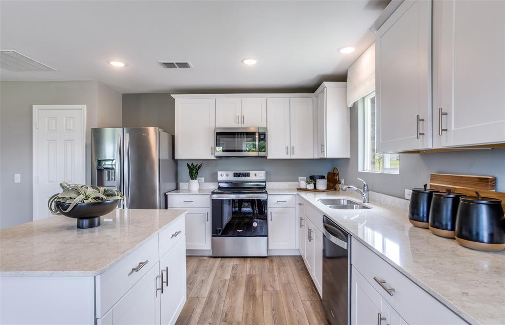 a kitchen with a sink a stove and cabinets