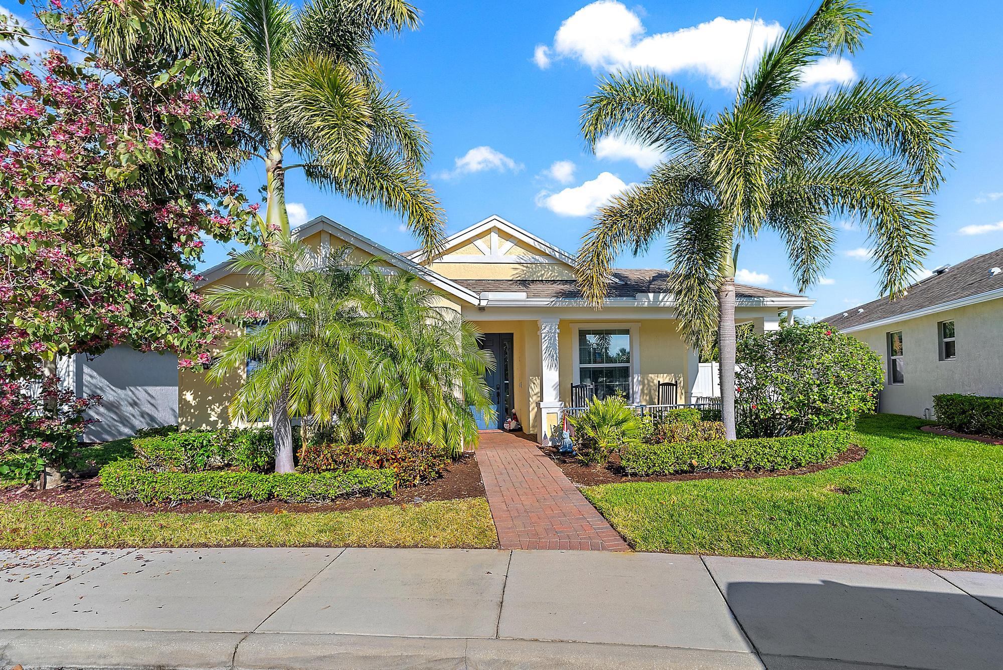 a front view of a house with a yard and potted plants