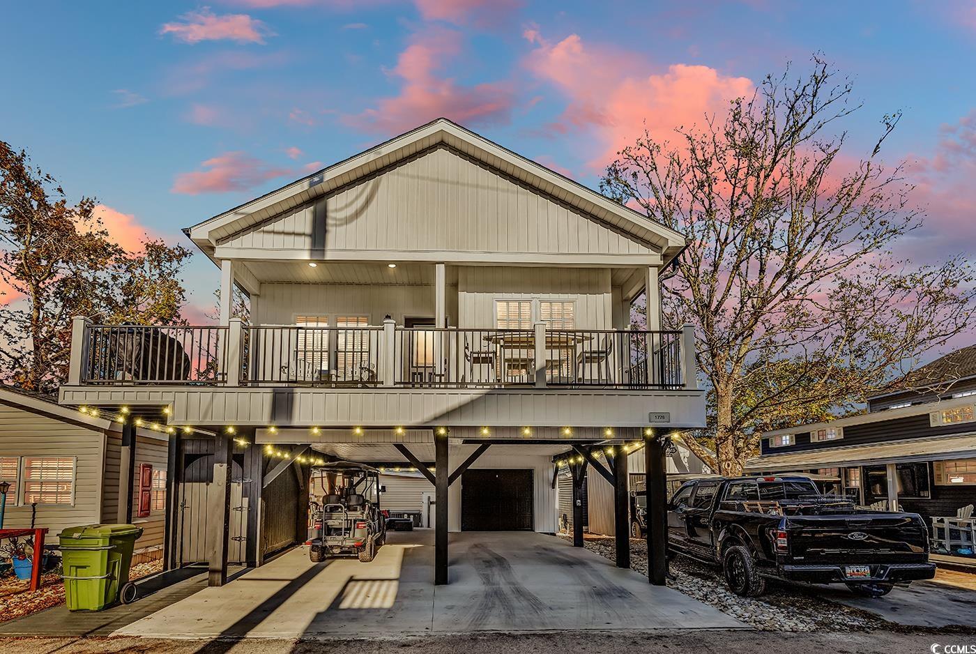 View of front of home with a carport, a garage, an