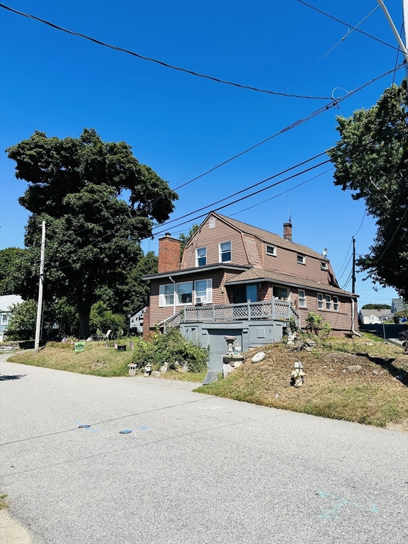 a view of a house with a small yard and potted plants