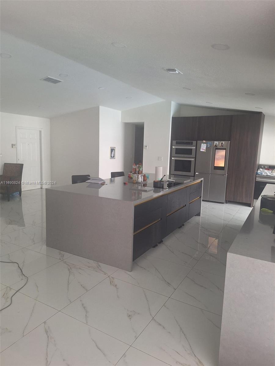 a kitchen with granite countertop a sink and cabinets